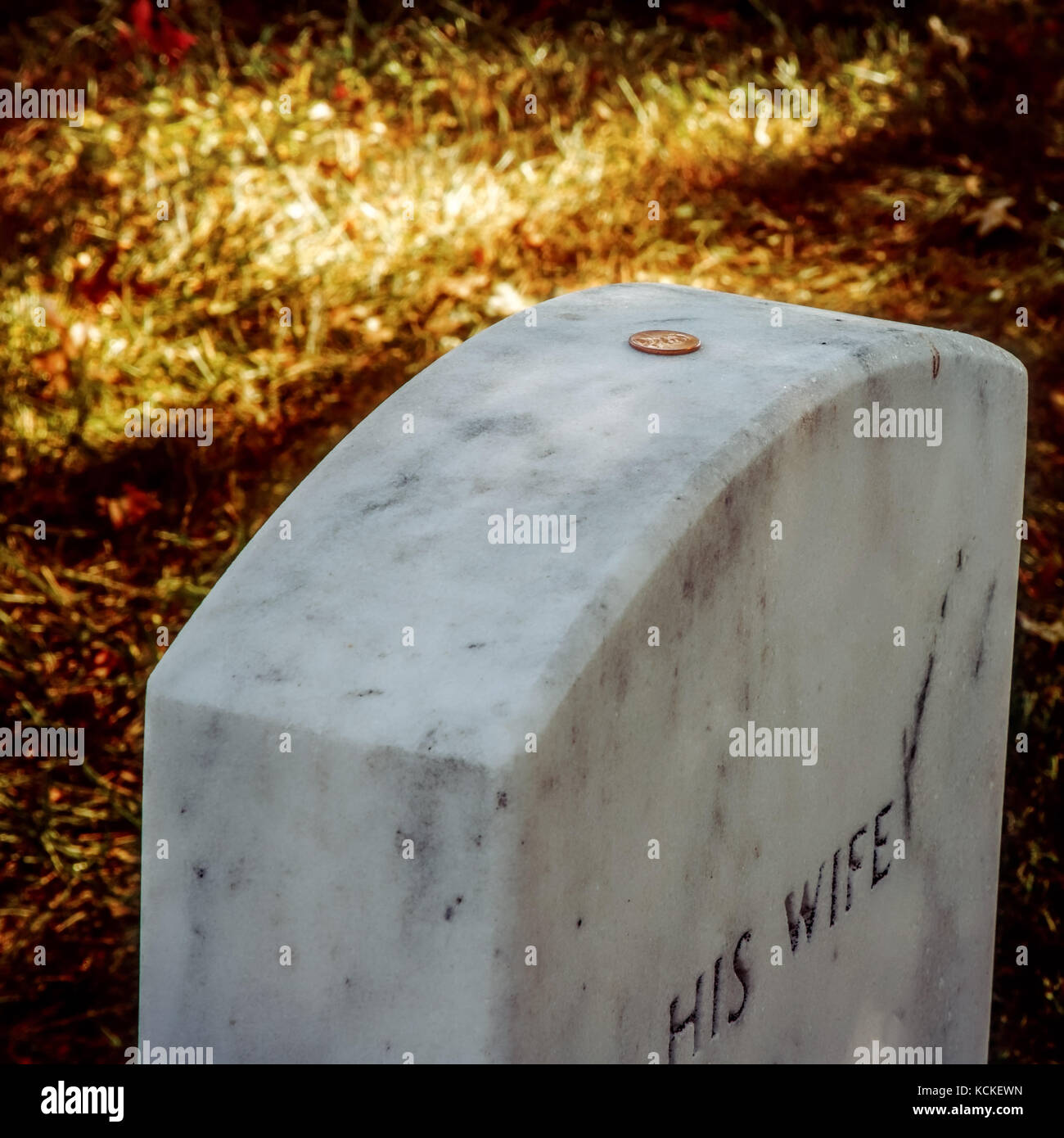 A penny sits on top the grave of a military