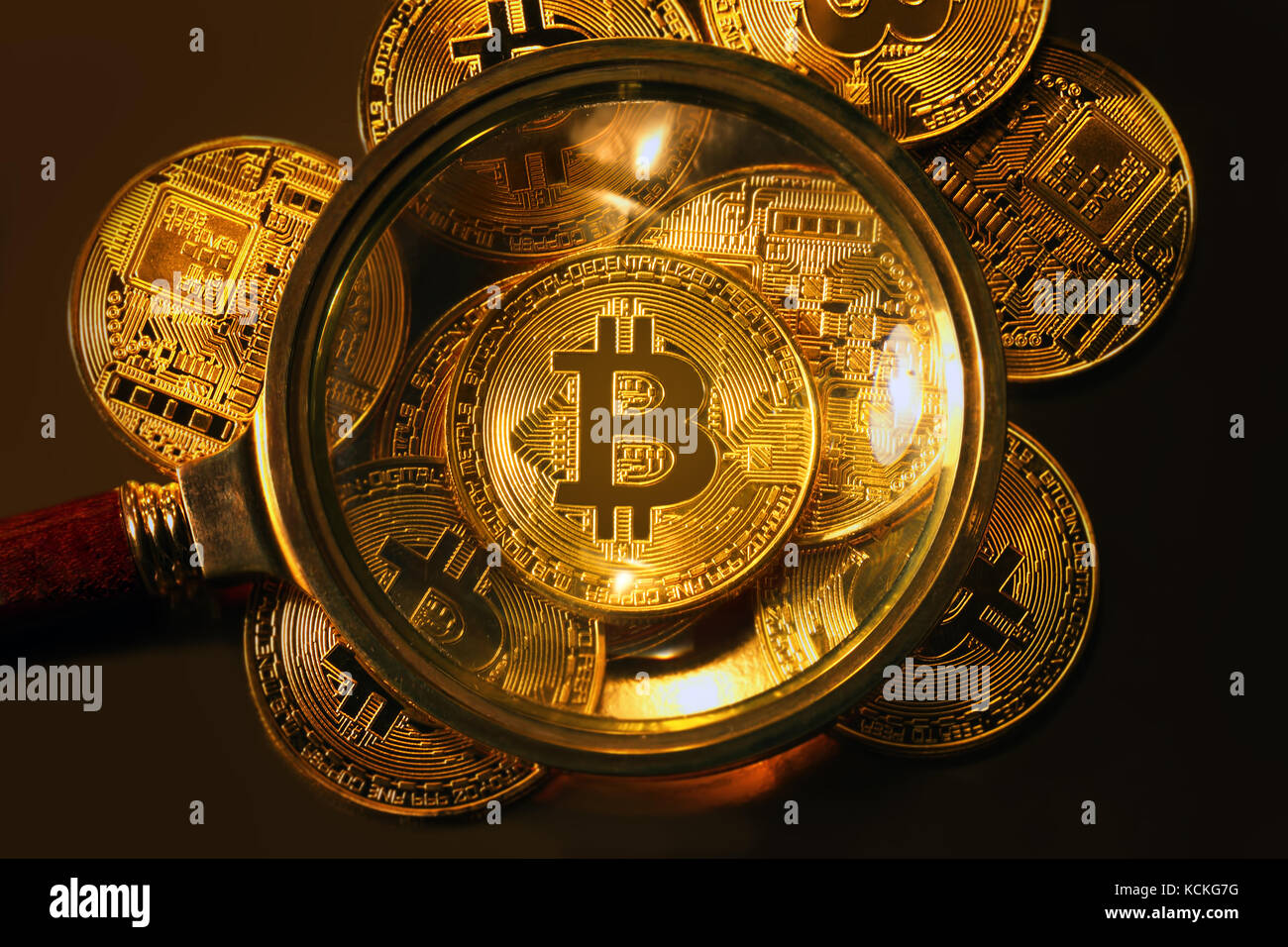 looking through a magnifying glass on new golden bitcoin Stock Photo - Alamy