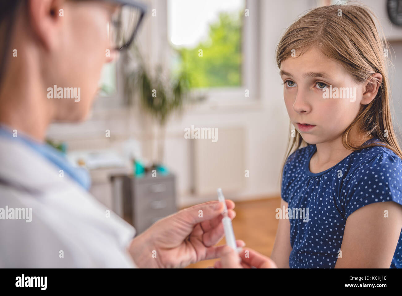 Pediatrics female doctor preparing a vaccine to inject into a patient Stock Photo