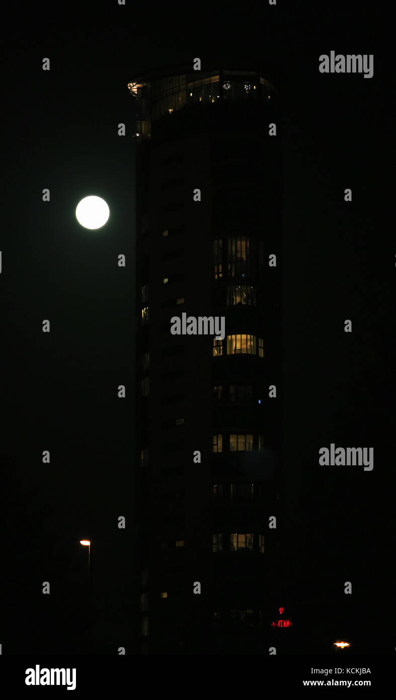 The harvest fool moon rises over Meridian Quay in Swansea Marina, Wales, UK. Stock Photo