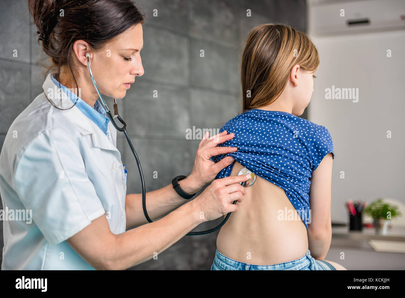Doctor listening to patients chest with stethoscope in his office at the hospital Stock Photo