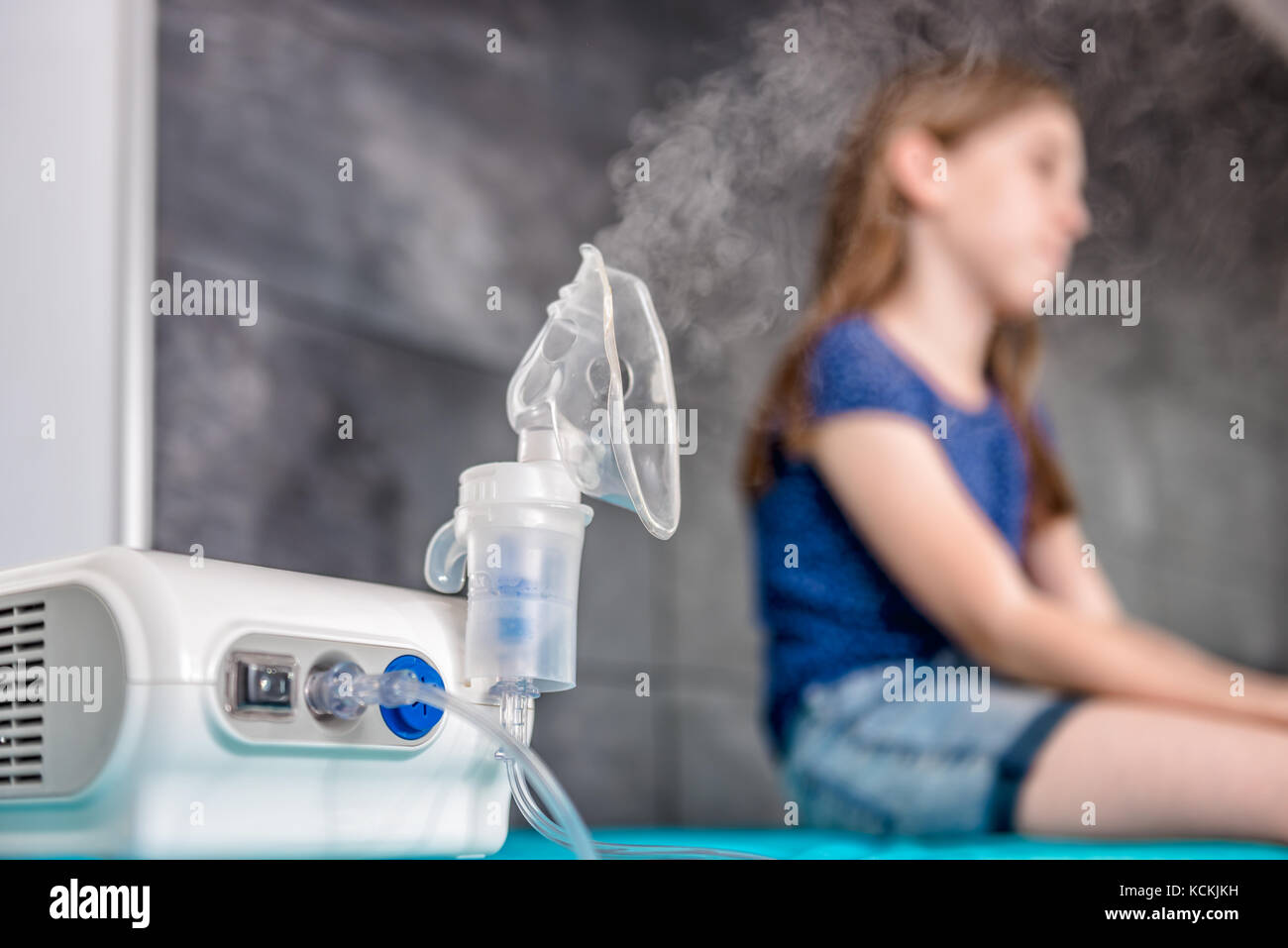 Little girl waiting for medical inhalation treatment with a nebulizer at the hospital Stock Photo