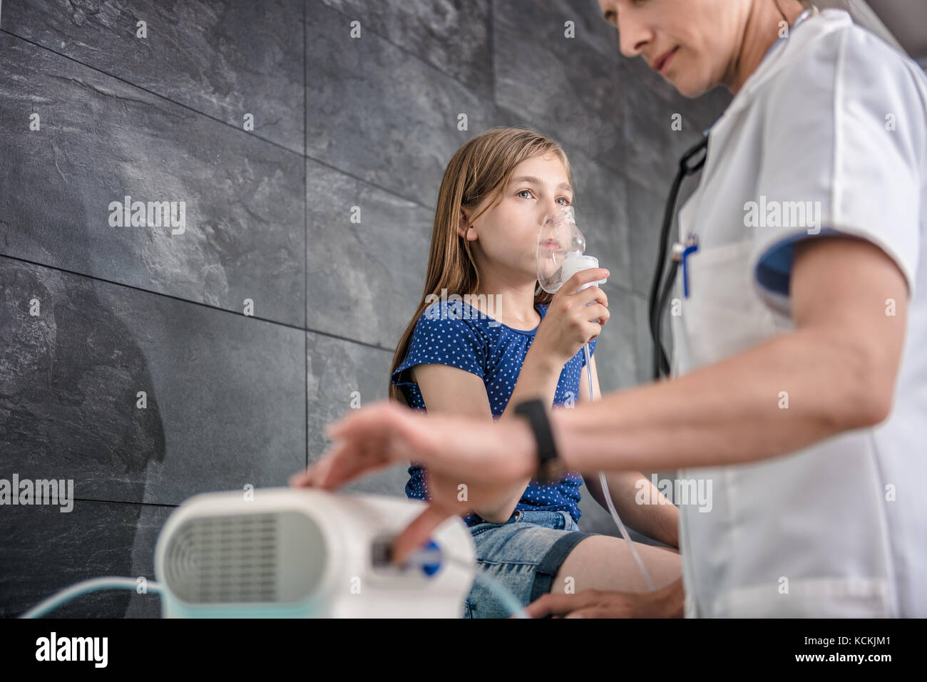 Little girl having a medical inhalation treatment with a nebulizer at the hospital Stock Photo