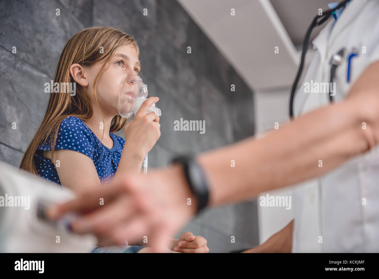 Little girl having a medical inhalation treatment with a nebulizer at the hospital Stock Photo