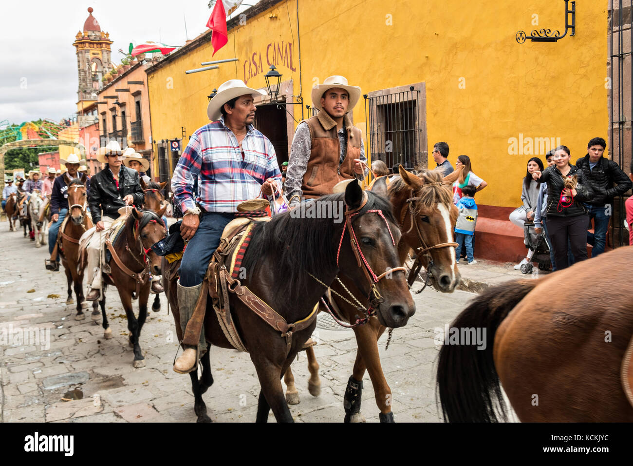 A procession of Mexican cowboys ride through the streets on the final