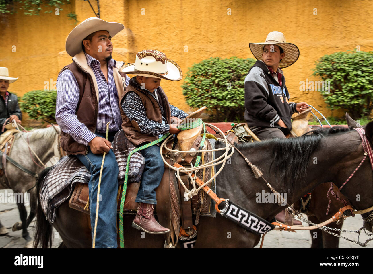 A procession of Mexican cowboys ride through the streets on the final