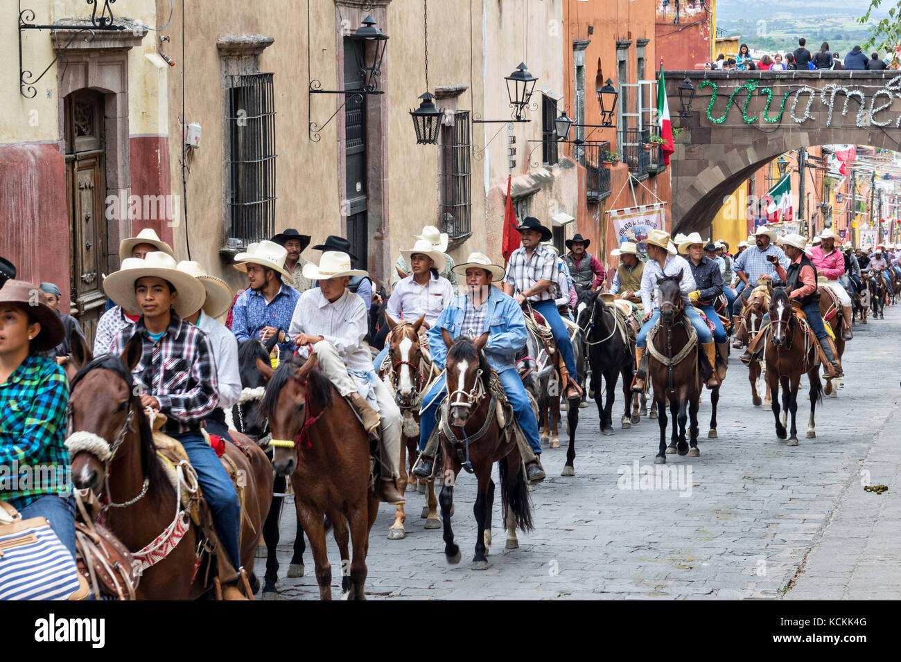 A procession of Mexican cowboys ride through the streets on the final