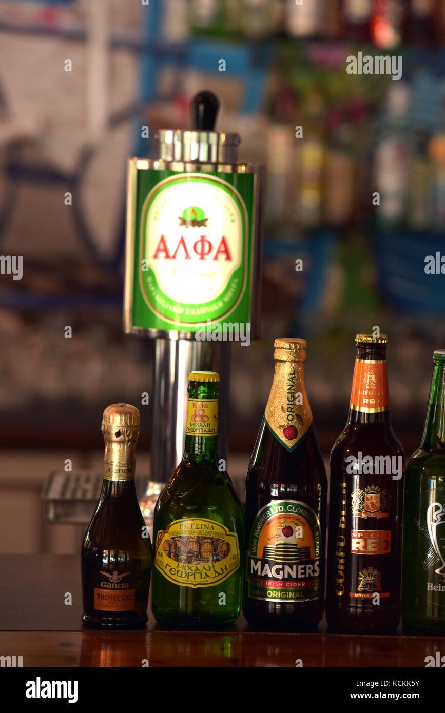 A greek bar with fraught beer pump and bottled beer on sale at a hotel. Ciders, beers and lagers being sold at a counter serving drinks and alcohol. Stock Photo