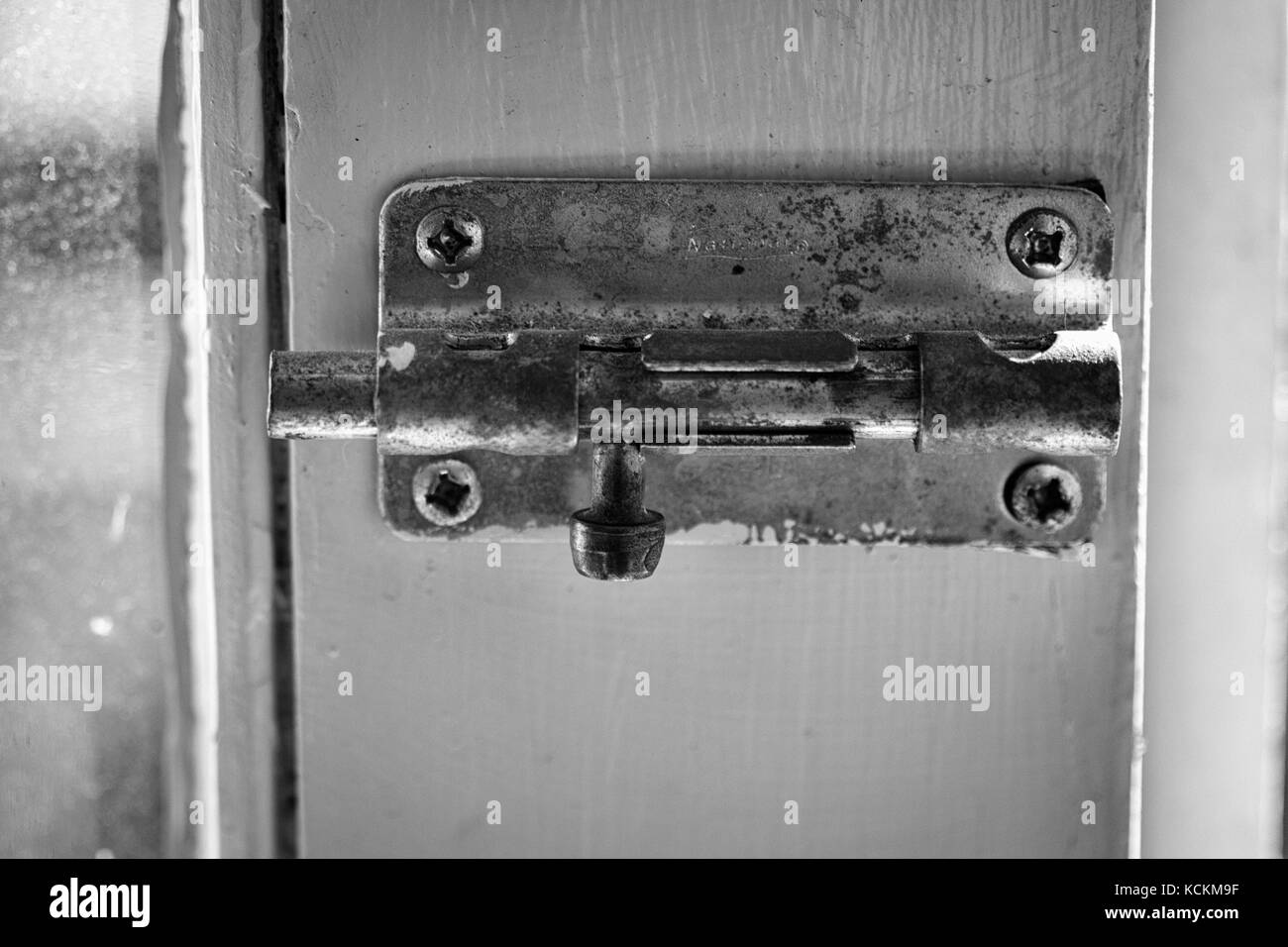 An old-fashioned slide latch lock on a white wooden door Stock Photo ...