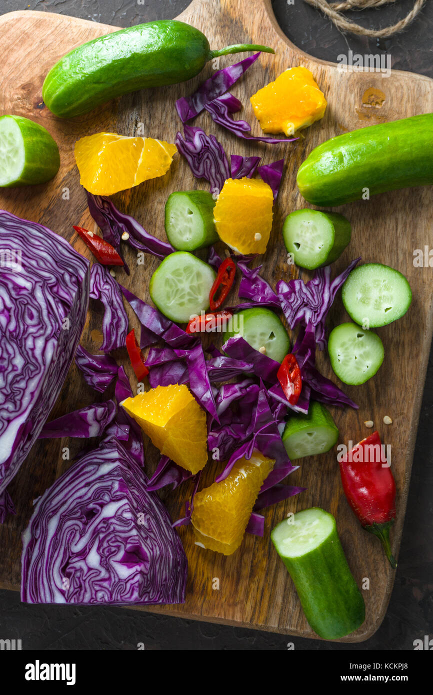 Assortment of fresh fruits and vegetables on wooden board vertical ...