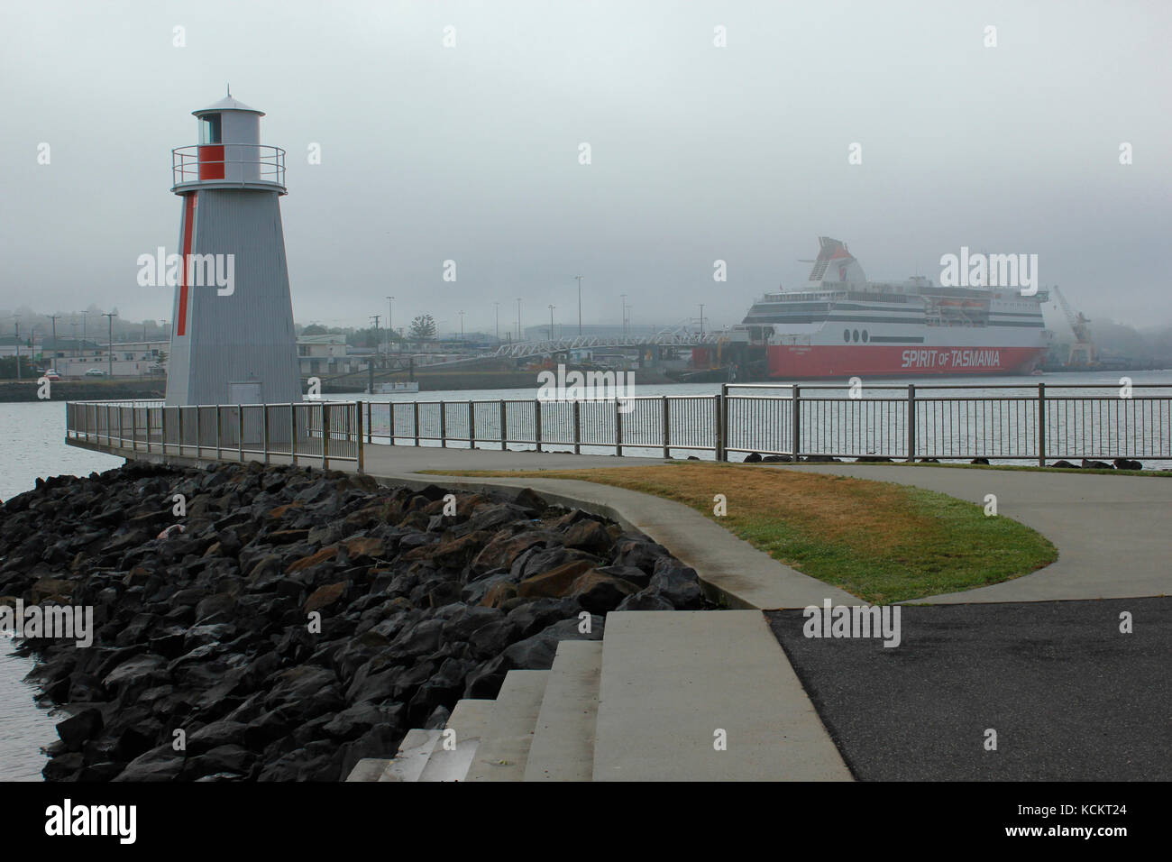Navigation marker for boats entering the port on a gloomy day, with the Bass Strait ferry ’Spirit of Tasmania’ in the background. Devonport, Tasmania, Stock Photo