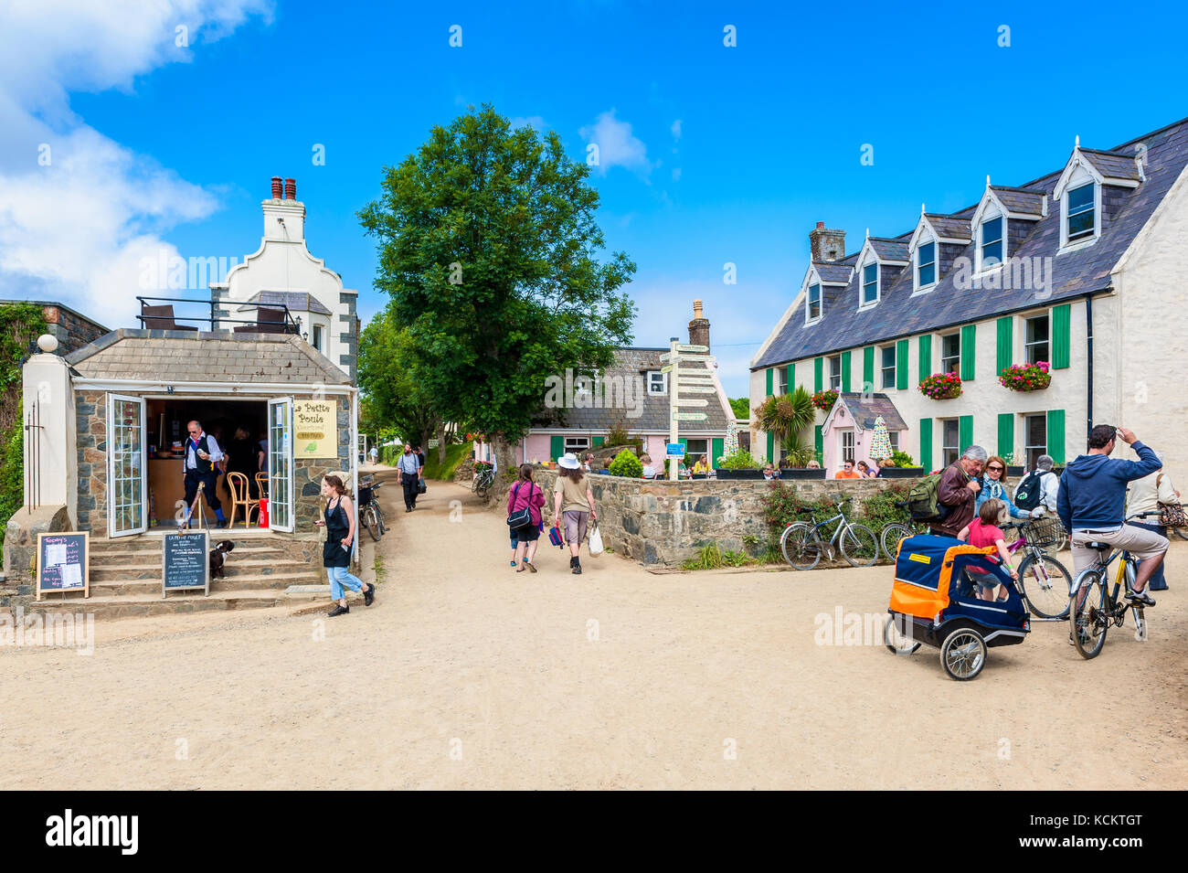 Unpaved street with restaurants and tourists in The Village, the center of Sark, Channel Islands, UK. No cars or trucks are allowed on Sark. Stock Photo