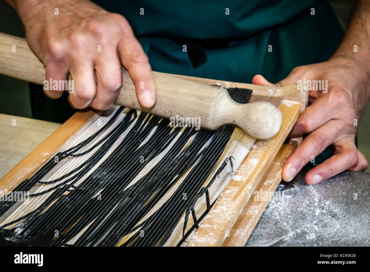 The individual steps of pasta production with the Carraturo. First, the dough is turned several times through a pasta machine until it is quite thin. Then the thin flap of dough can be pressed with a rolling pin through the wires that cut it into thin strips. Then briefly flour and cook in salted water until al dente just before eating. At the side of the chef is Salvatore Piacente, also a graduate of the Santa Maria cooking school, where José Graziosi already learned his craft Stock Photo