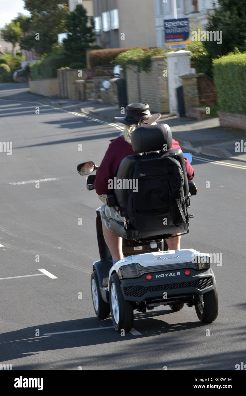 An Disabled Elderly Gentleman On A Mobility Scooter On The Road On The Seafront Speeding Along 