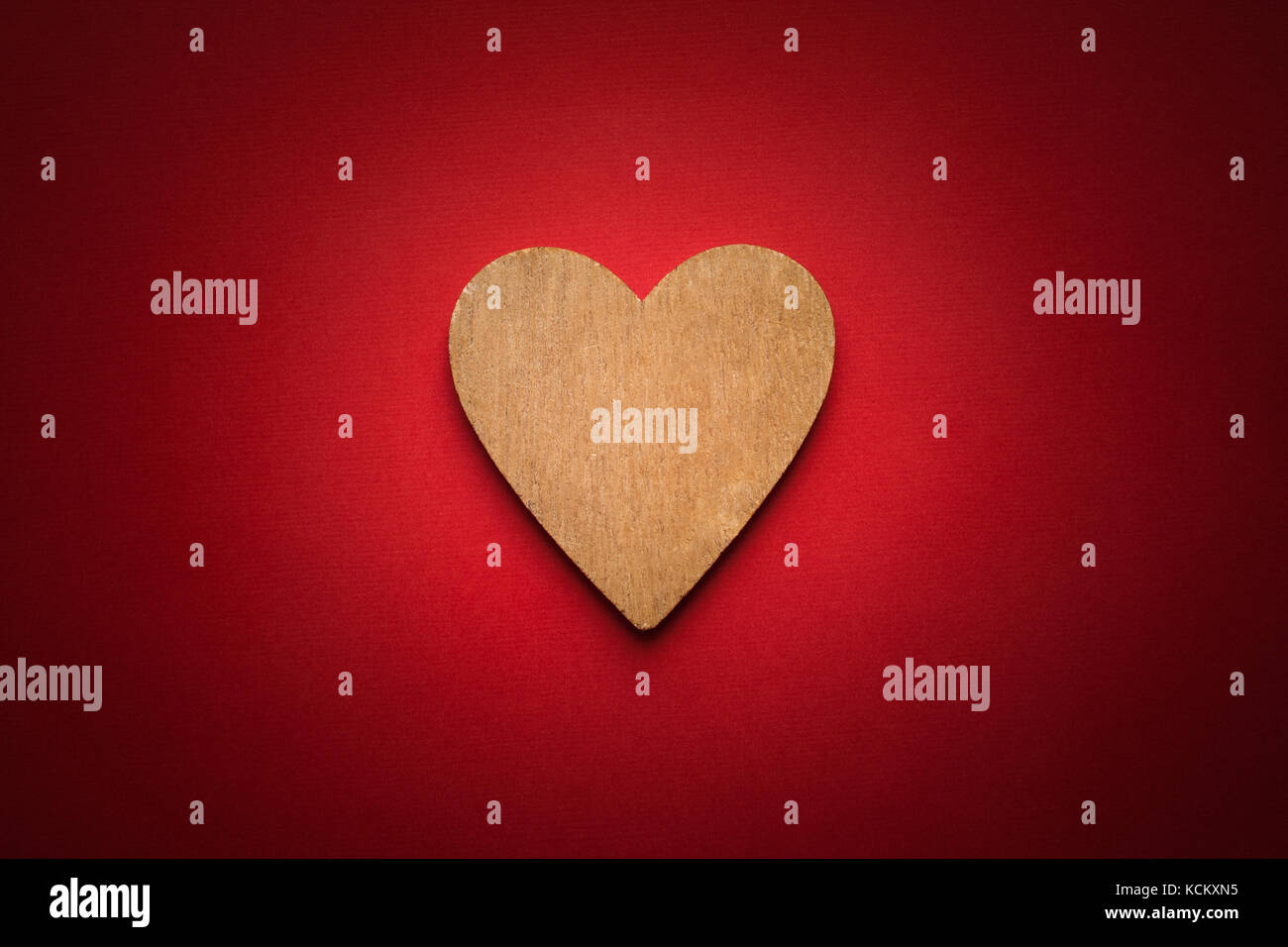 One Wooden Brown Heart On Red Paper Background With Vignette Stock ...