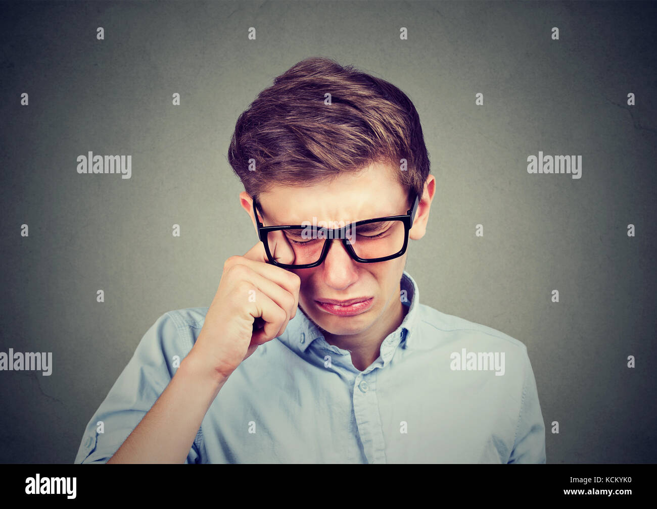 Closeup of a crying teenager man in glasses Stock Photo