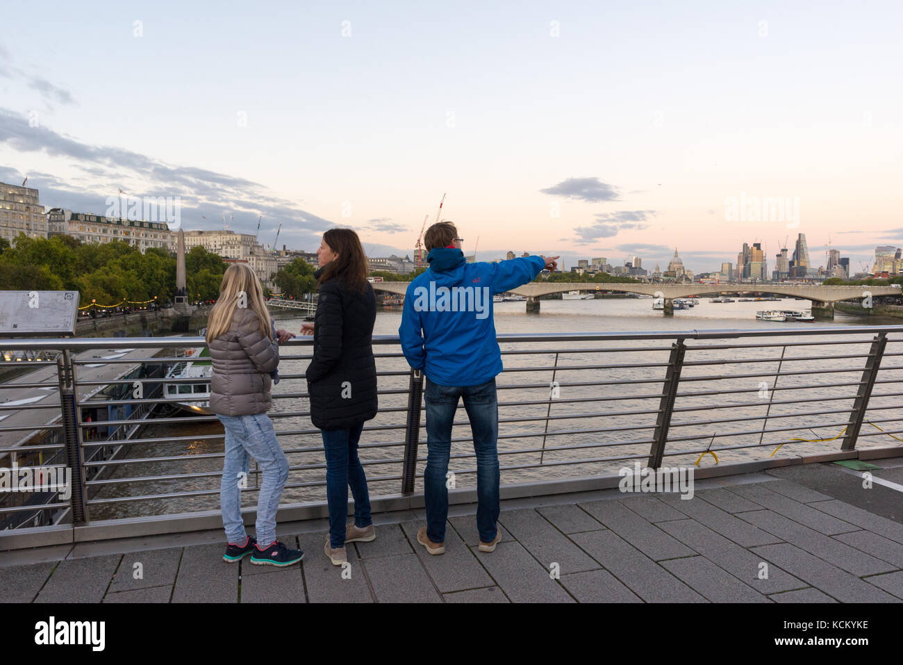 Tourists taking in the evening view down The Thames from Golden Jubilee Bridge, London, England, UK Stock Photo