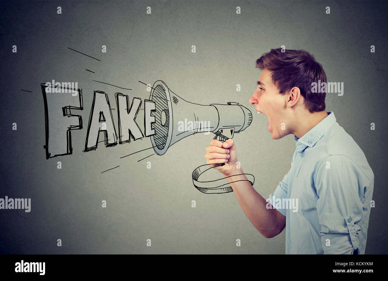 Young man screaming in a megaphone spreading fake news Stock Photo