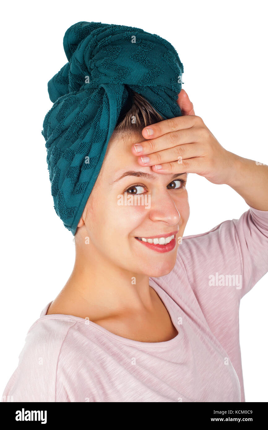 Happy young woman with towel on head applying facial moisturizer after