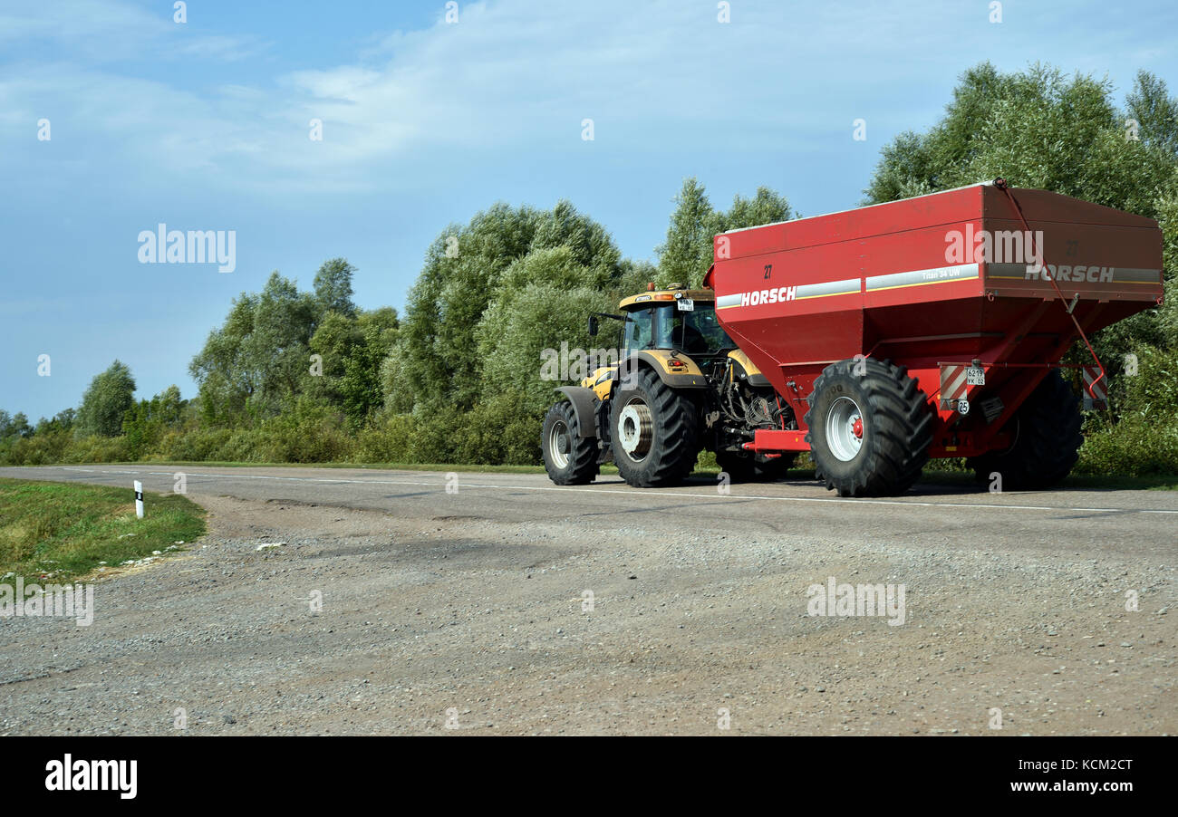 Modern huge yellow Challenger MT685D Tractor travelling on a road with a red Horsch seed sowing machine Stock Photo
