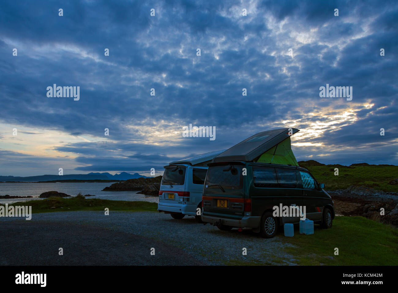Two Mazda Bongo camper vans on the Rhue road, near Arisaig, Scotland, UK.  The Isle of Rum in the distance. Stock Photo
