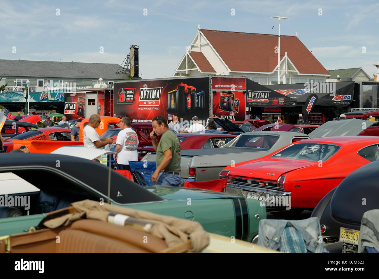 Three spectators talk amid the cars on display at the annual  Endless Summer Cruisin, Ocean City, Maryland, USA. Stock Photo