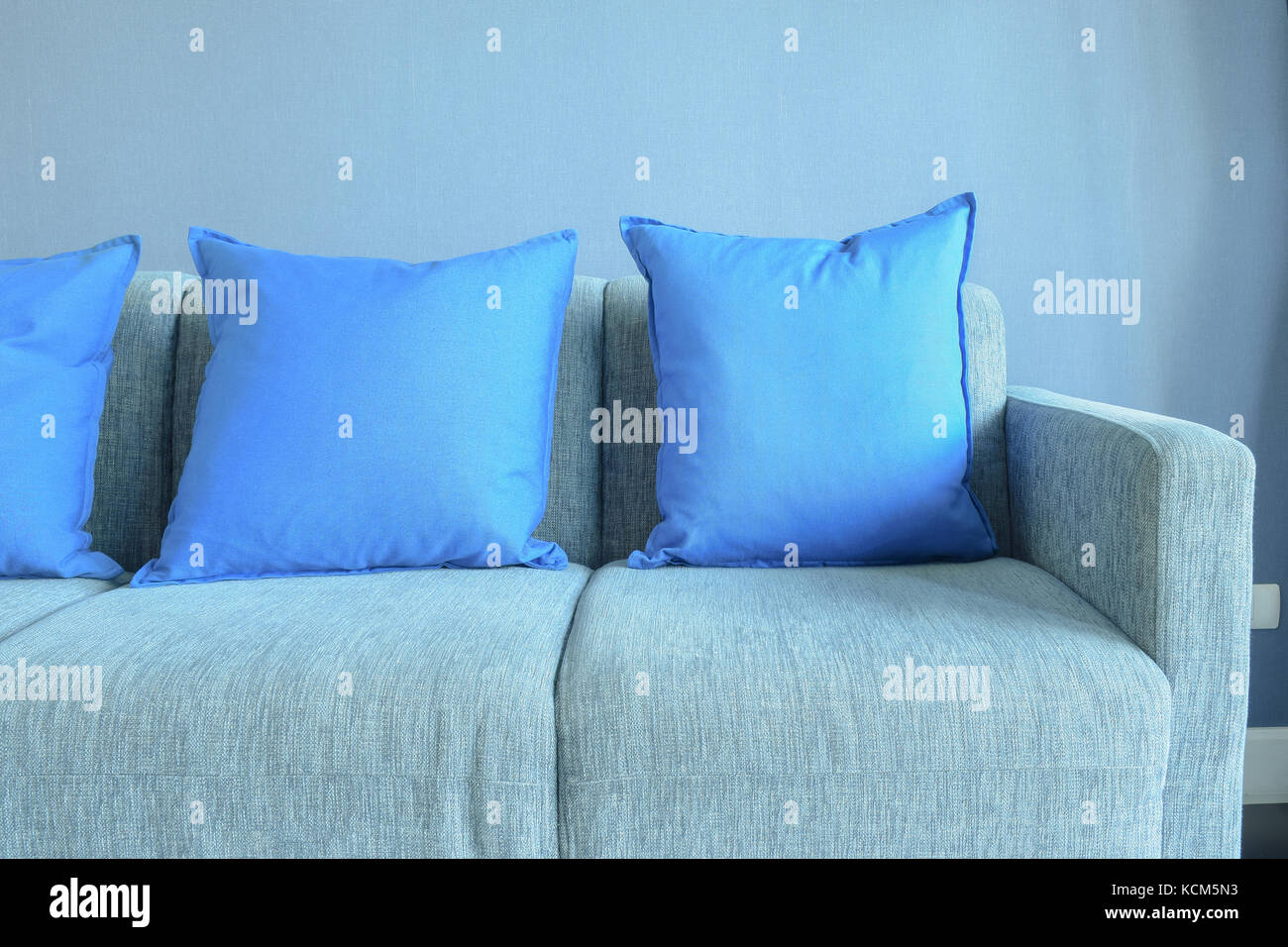 Blue color pillows setting on light blue sofa with blue wall Stock