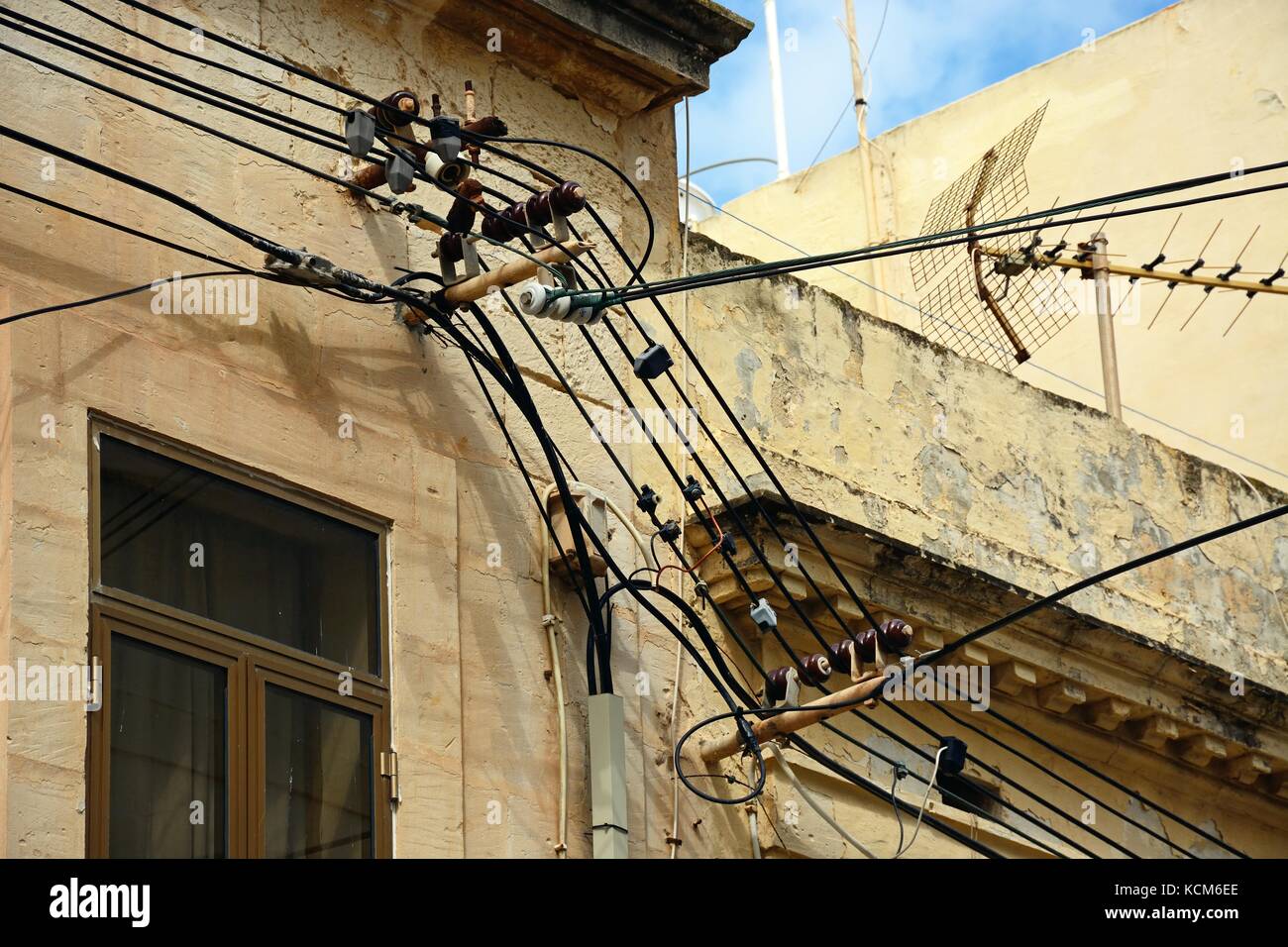 Electricity cables and a TV aerial on the front of a building, Bugibba
