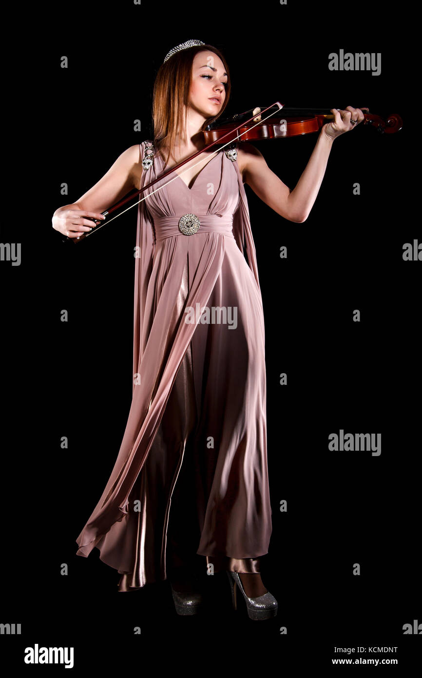 Pretty young woman playing a violin over black background Stock Photo ...