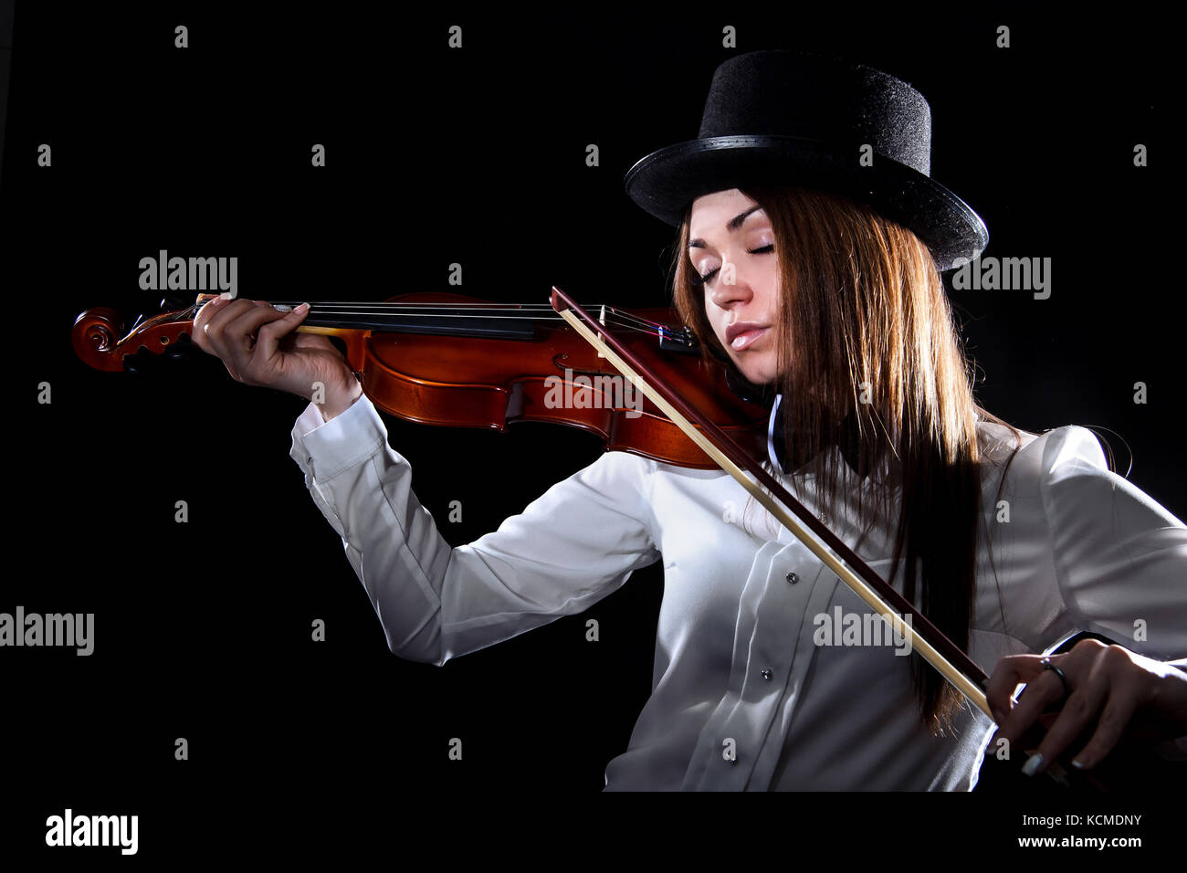 Pretty young woman playing a violin over black background Stock Photo ...