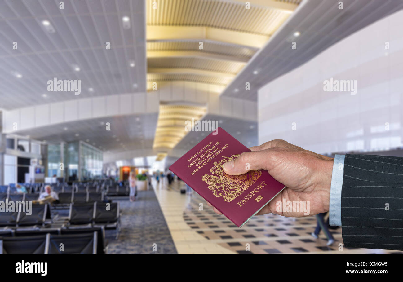 Senior executive arm holding UK Passport at airport terminal Stock Photo