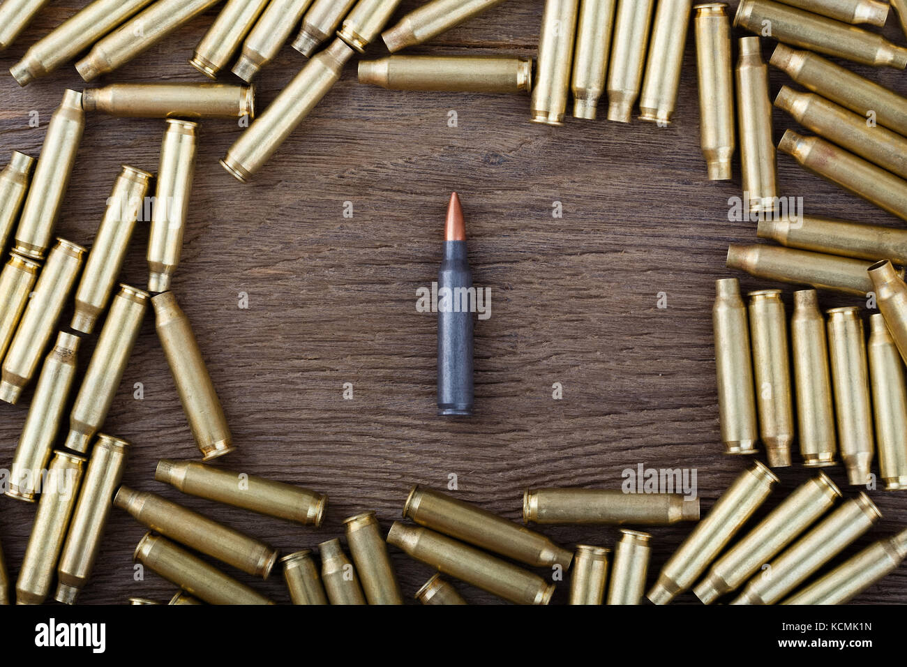Ak-47 cartridges on wooden table close-up. Stock Photo