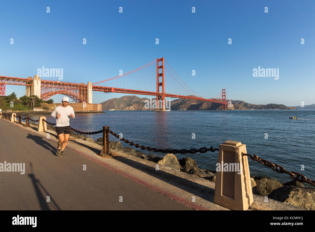 San Francisco, California, USA - September 15th, 2017: A man is jogging on the Marine Dr road, The Golden Gate Bridge as a Background. Stock Photo
