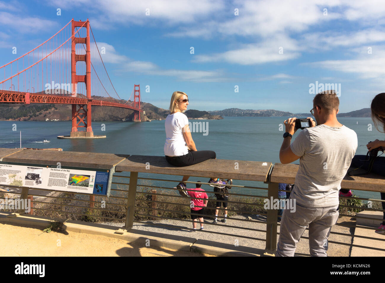 San Francisco, California, USA - September 15th, 2017: A young man is taking a photo of a blonde woman at the Golden Gate National Recreation Area. Stock Photo