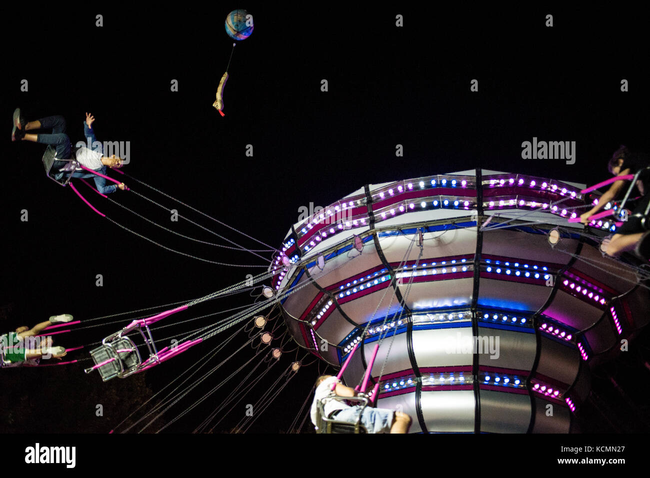 A funny ride in chairoplane with friends in an amusement Italian park at night Stock Photo