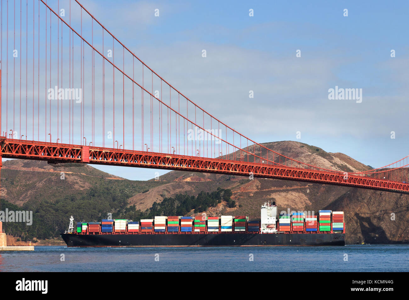 View of a container ship passing under the Golden Gate Bridge, San Francisco. Stock Photo