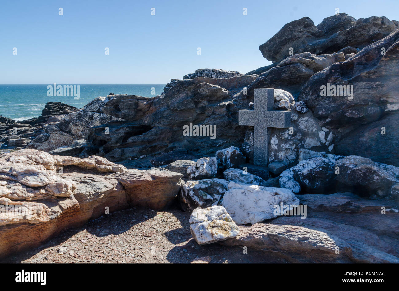 Unnamed grave and cross in natural setting between rocks with sea in background, Luderitz Peninsula, Namibia, Africa Stock Photo