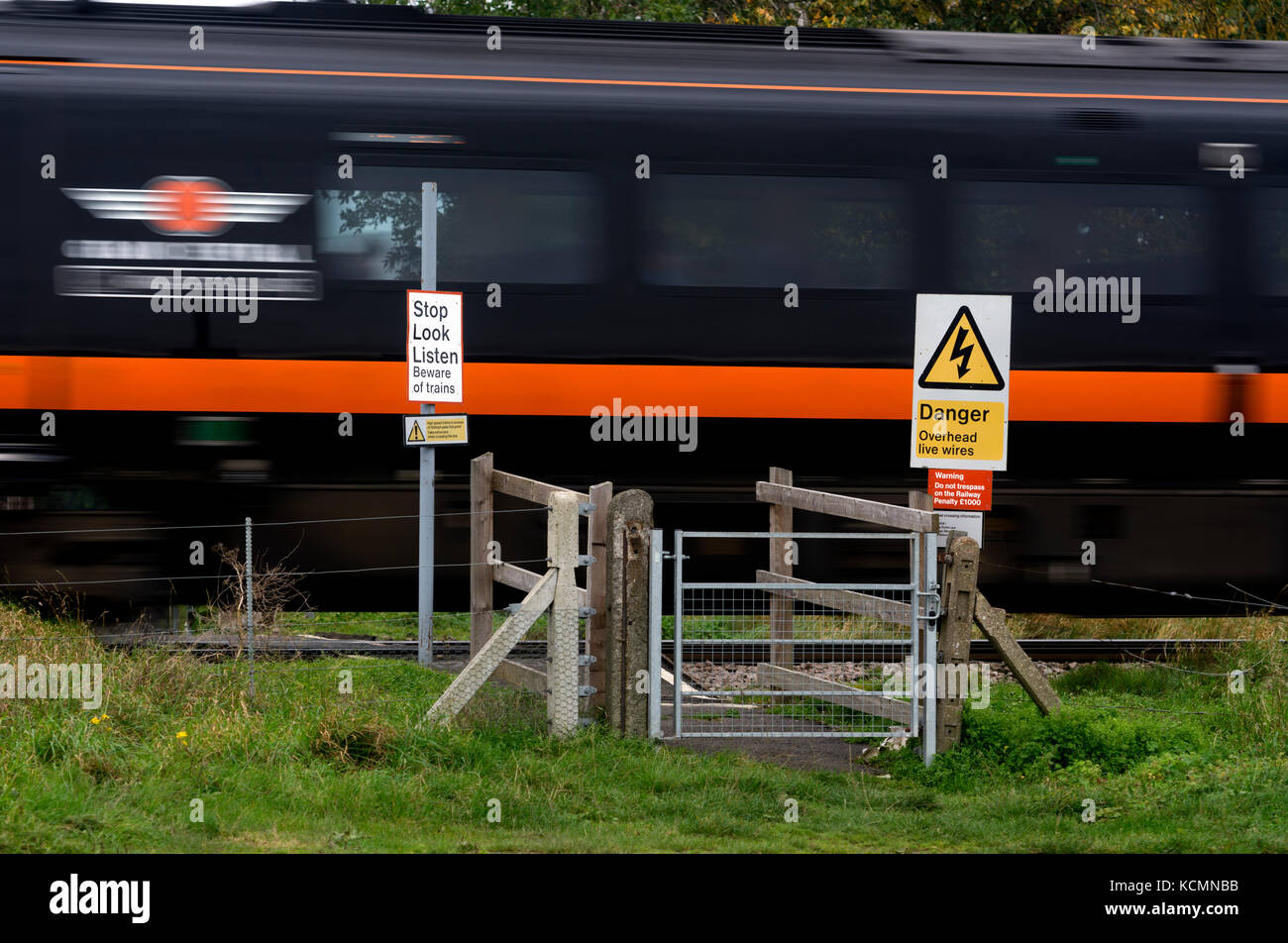 Grand Central train at speed passing a foot crossing on the East Coast Main Line, Nottinghamshire, England, UK Stock Photo