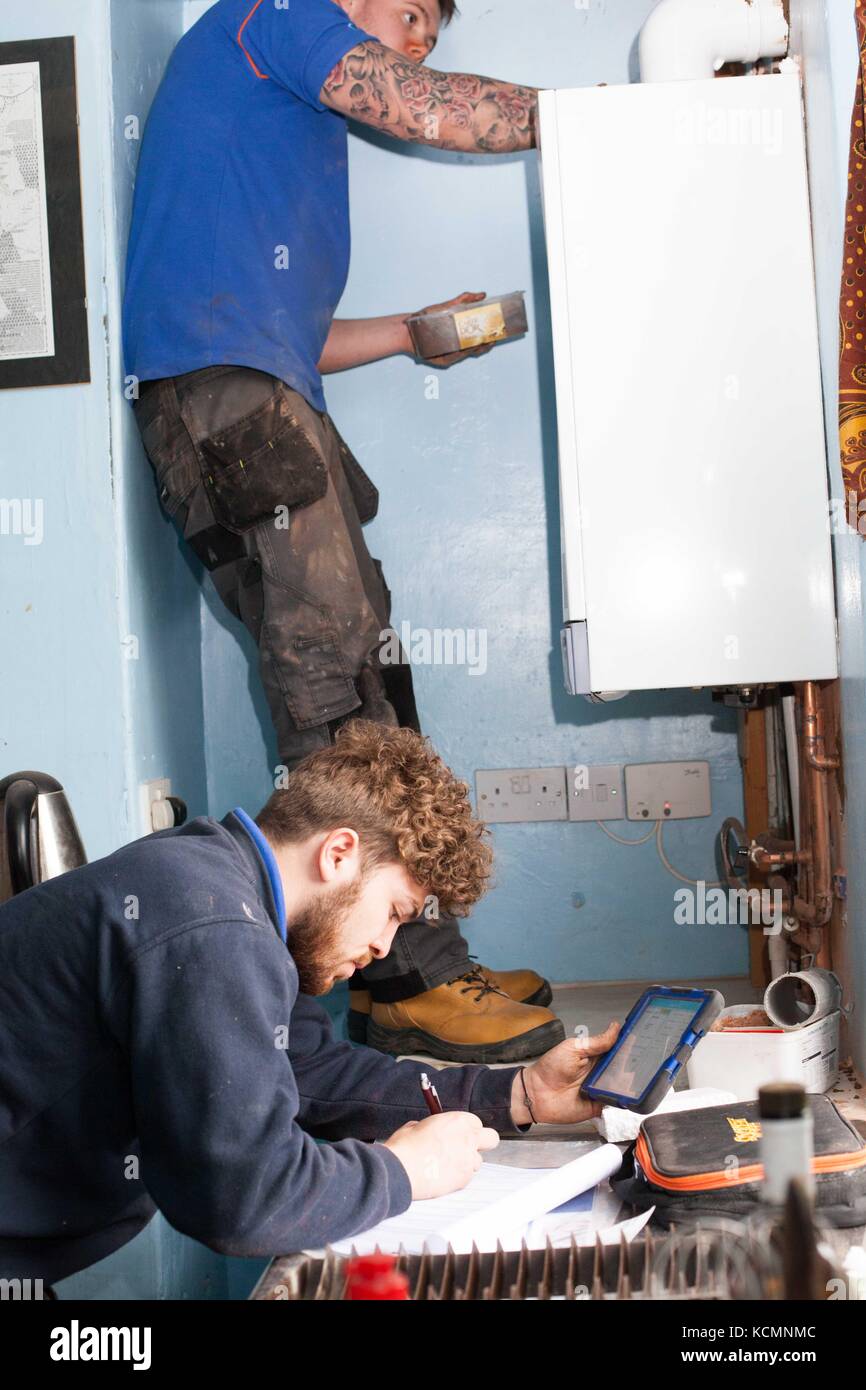 British Gas removing old inefficient boiler ,which creates too much CO2 into the atmosphere .To be replaced by new efficient model .UK government initiative to meet international targets on Climate Change ,such as Paris Accord. At reduced cost . Stock Photo