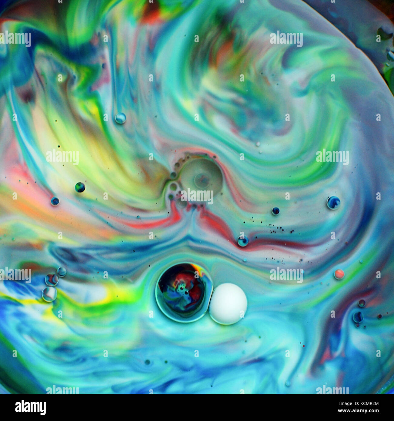 Food colouring poured into milk and oil to give colourful swirls Stock Photo