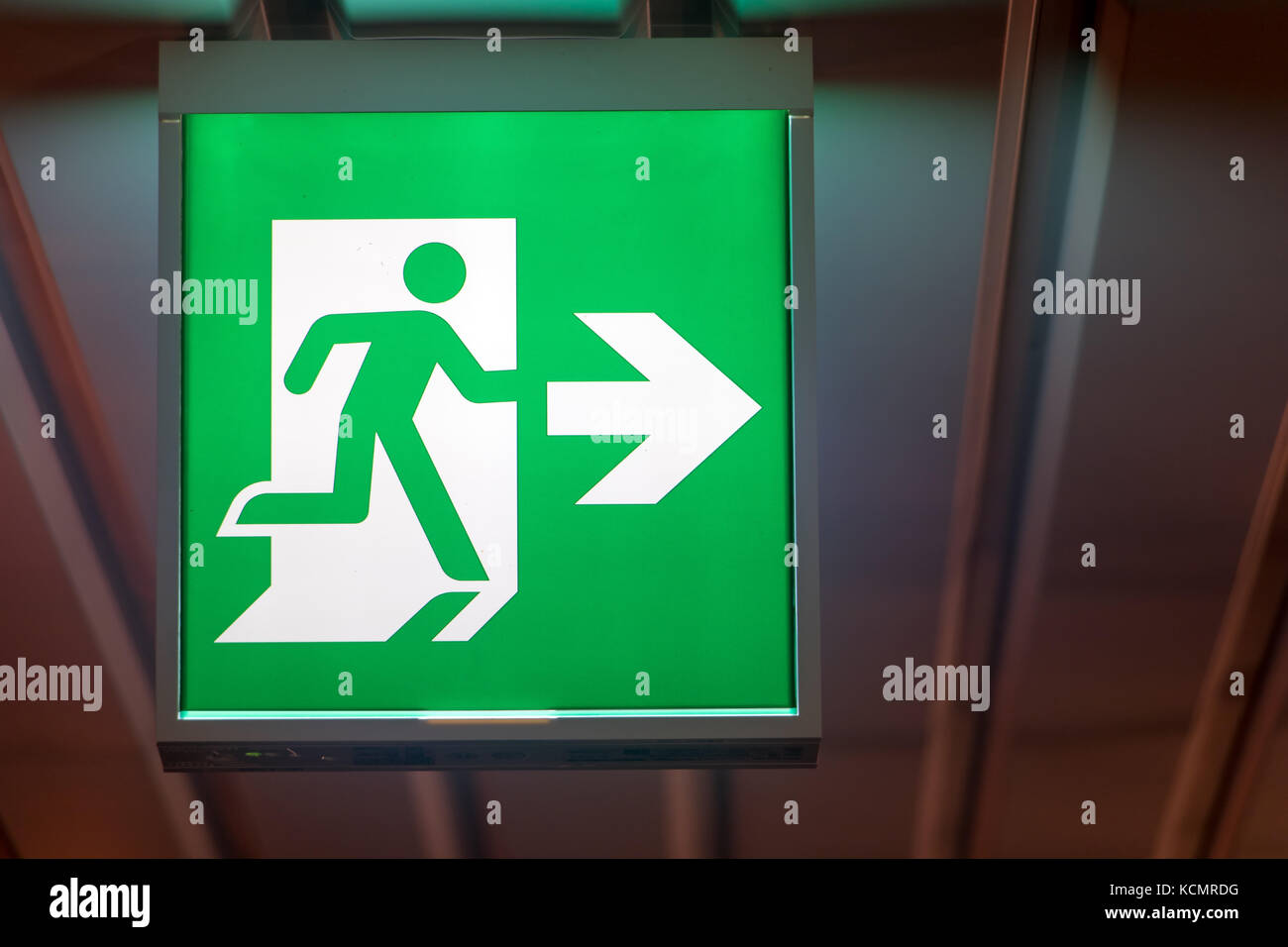 The emergency exit sign shows the direction of escape in case of danger