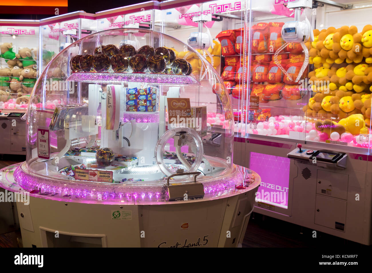 Gaming club with crane machines. Play room with automate for sweets. Stock Photo
