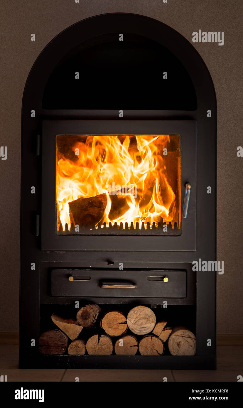 The burning stove in the apartment. The fireplace stove at home Stock
