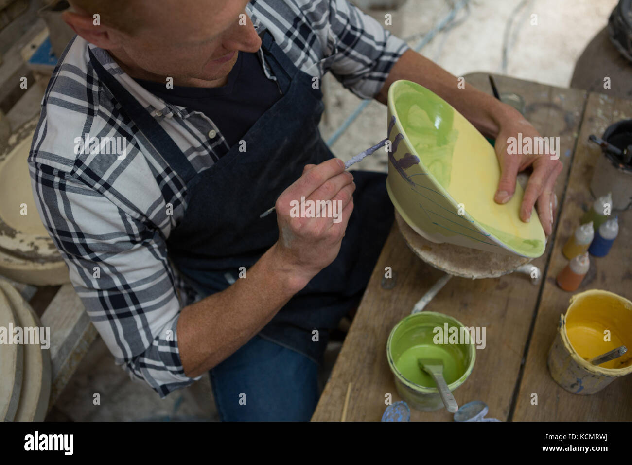 Male potters hand painting a bowl in pottery workshop Stock Photo - Alamy