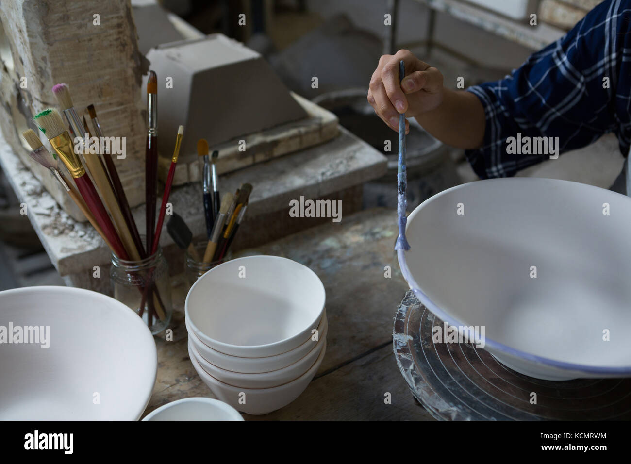 Female potter painting a bowl in pottery workshop Stock Photo - Alamy