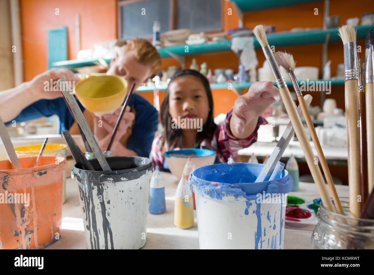 Male potter and girl painting bowl in pottery workshop Stock Photo - Alamy