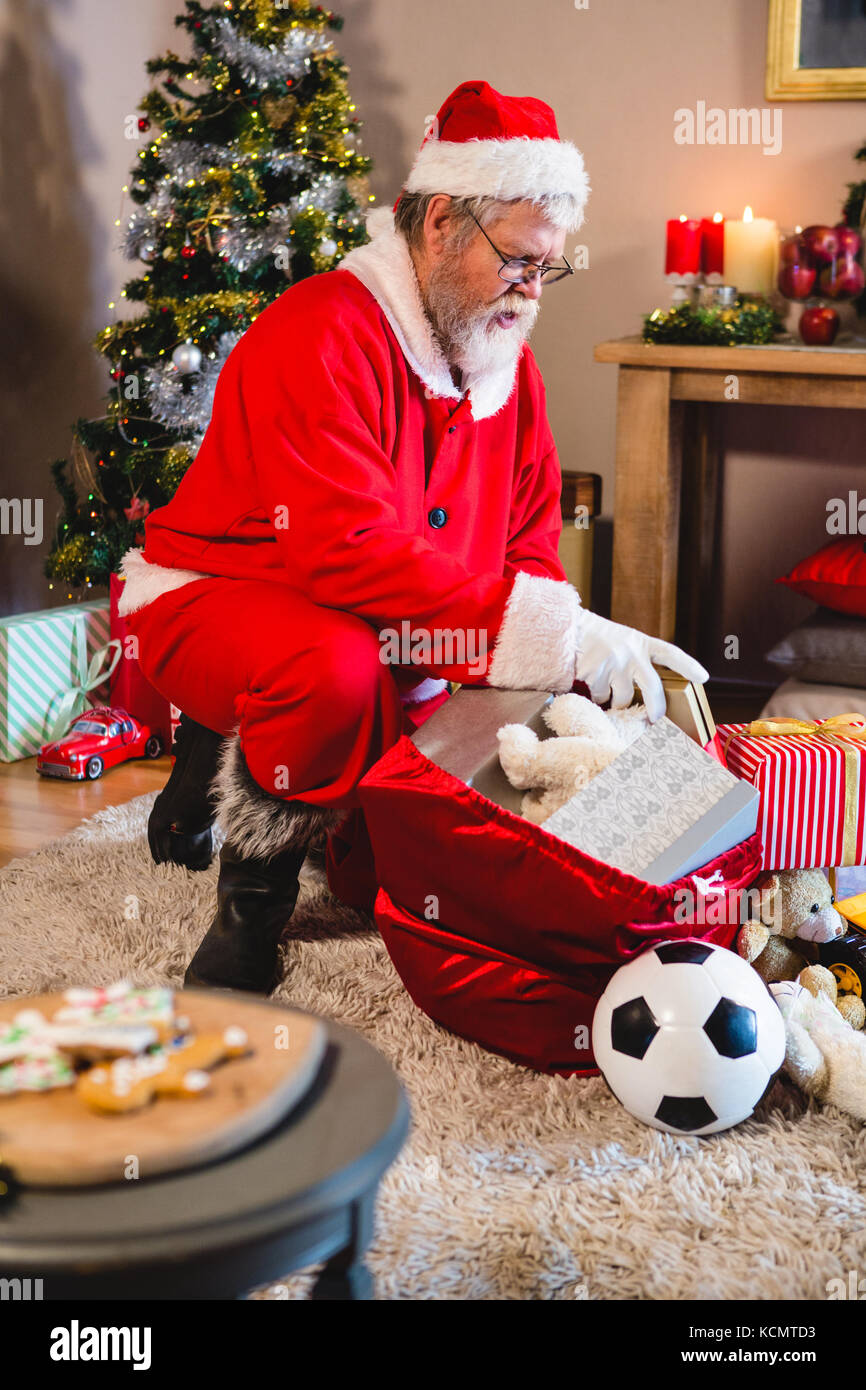 Santa claus listening music on mobile phone at home during christmas time Stock Image