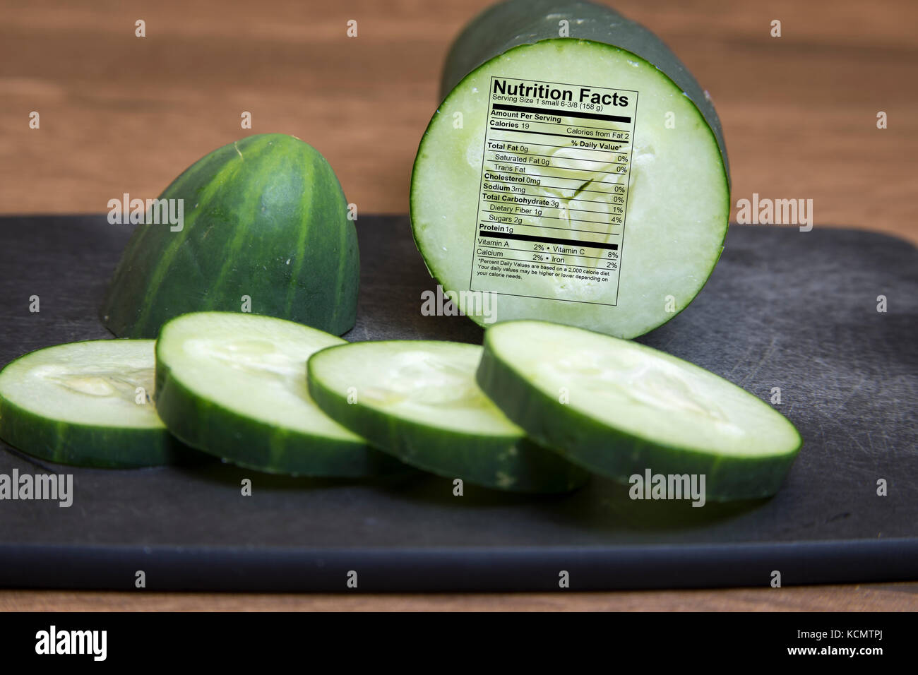 Raw cucumber sliced on cutting board with nutritional fact label Stock