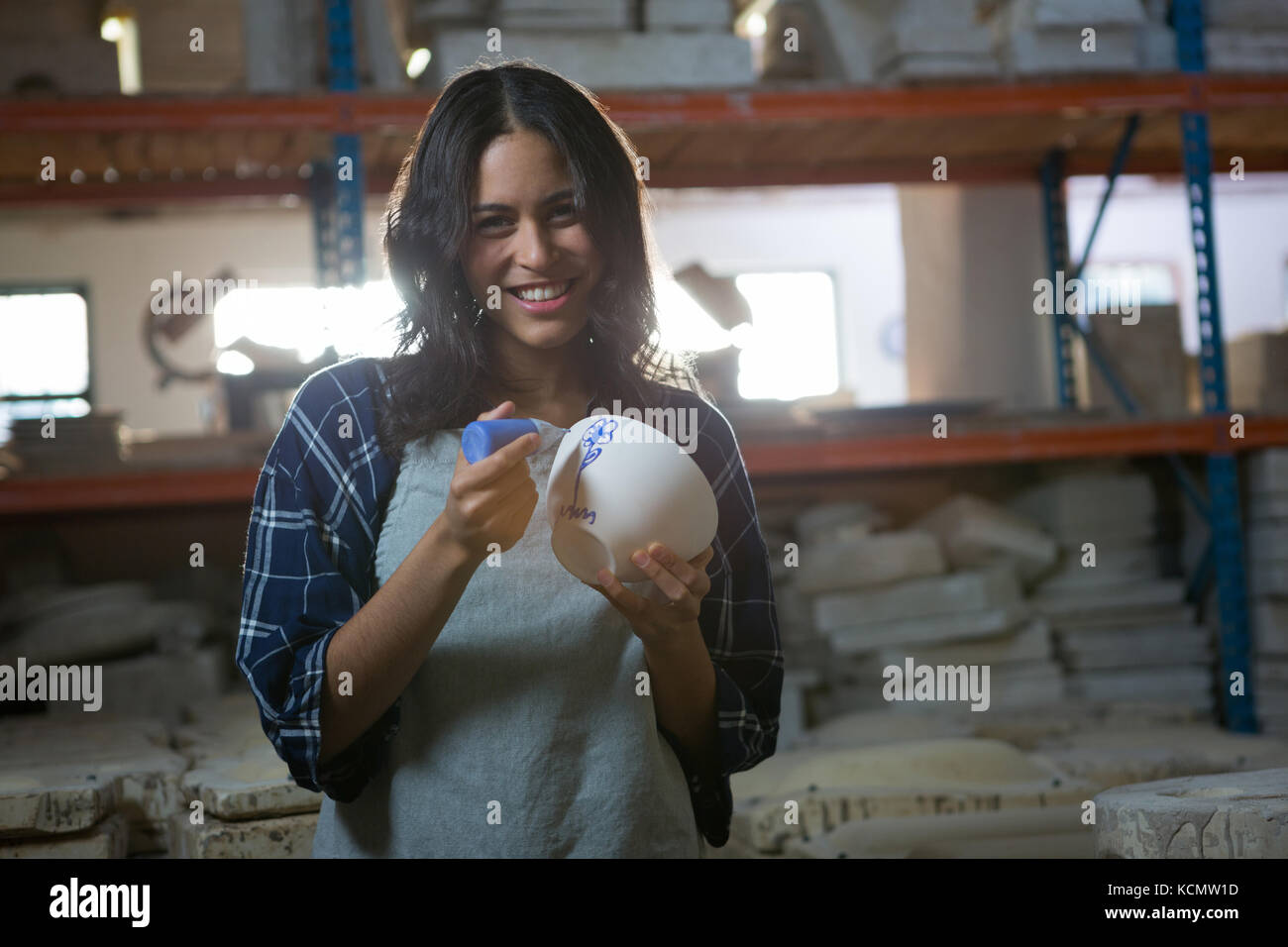 Female potter painting a bowl in pottery workshop Stock Photo - Alamy