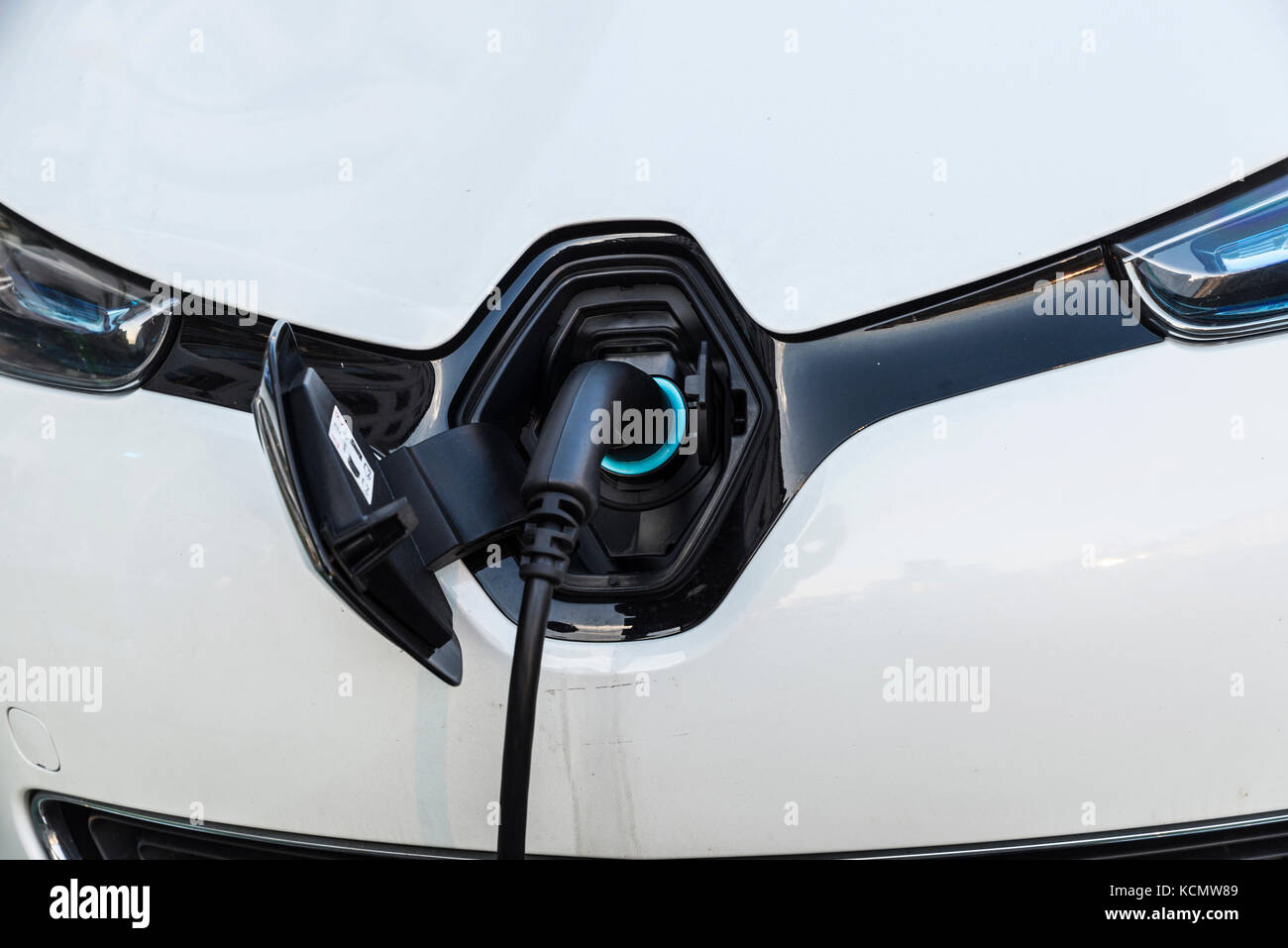 Electric car recharging batteries at a recharge point on a street in